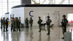 Polisi militer dan anjing pelacak berada di dekat lokasi ledakan di Bandara Internasional Pudong, Shanghai, China, Minggu (12/6). Polisi berhasil mengendalikan lokasi dan tak ada jadwal penerbangan yang terganggu akibat peristiwa itu. (REUTERS/Aly Song)