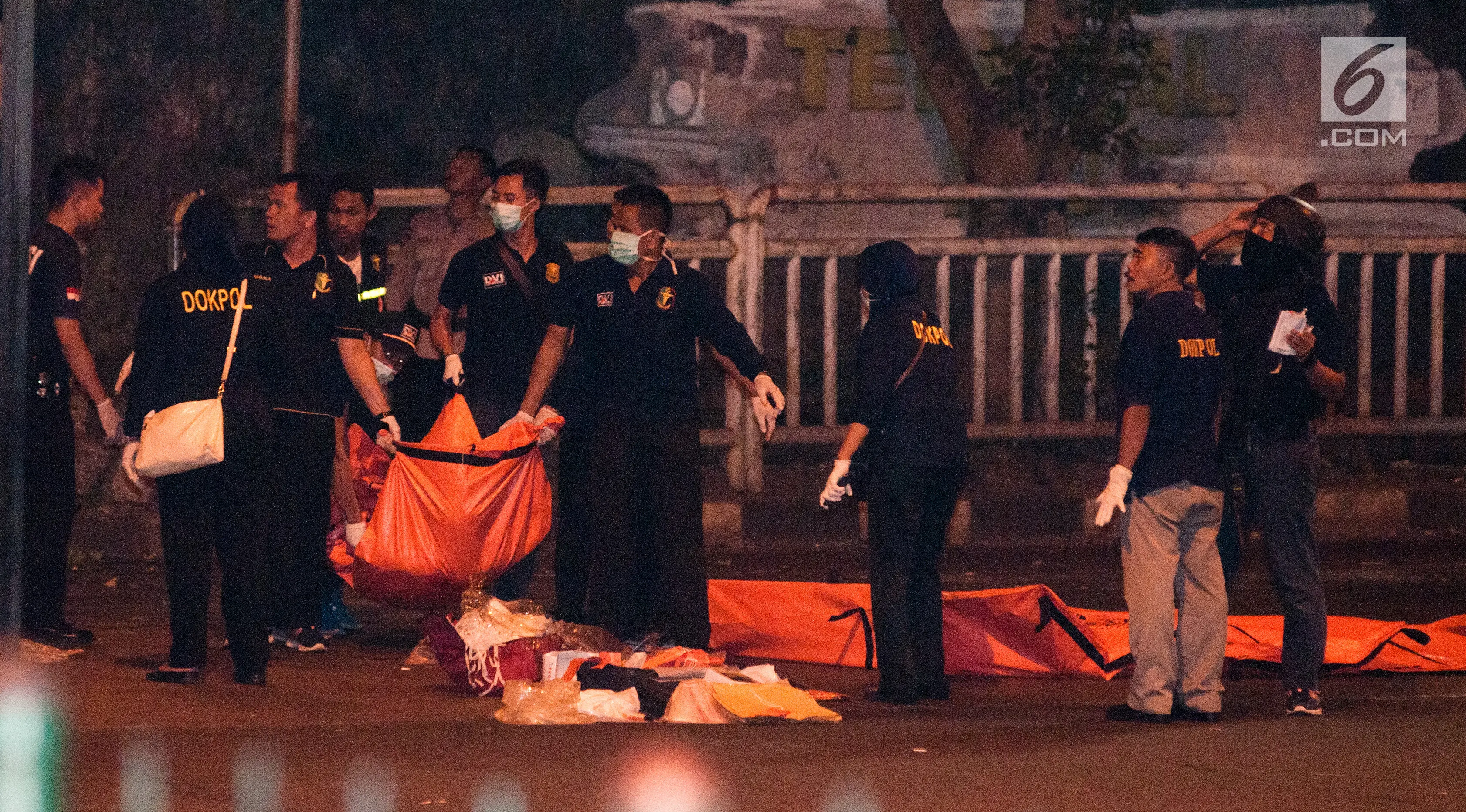 Polisi dan Puslabfor mengevakuasi potongan jenazah ketika  olah TKP ledakan di Terminal Kampung Melayu, Rabu (24/5). Selain memotret dan menyusuri lokasi, petugas juga berjaga di lokasi ledakan. (Liputan6.com/Yoppy Renato)