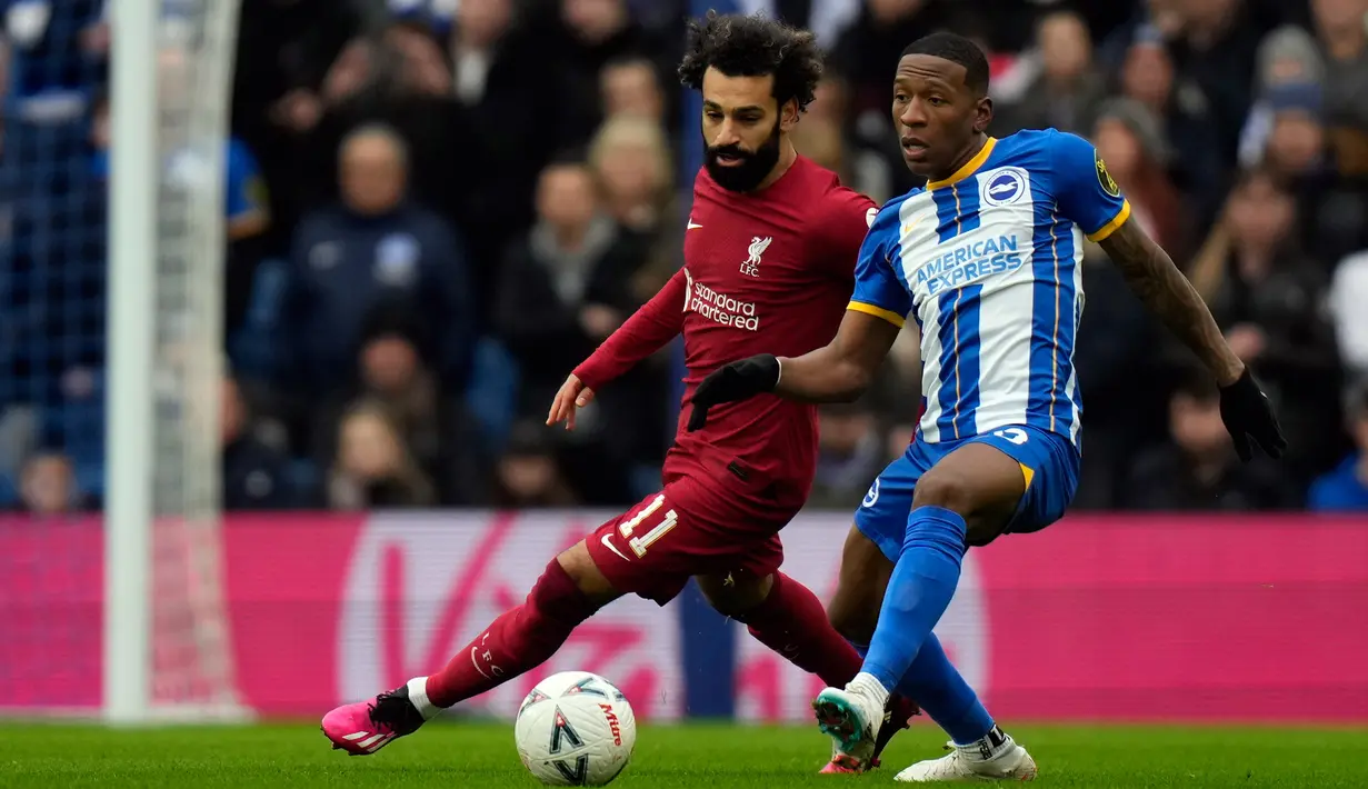 Pemain Liverpool Mohamed Salah (kiri) berebut bola dengan pemain Brighton and Hove Albion Danny Welbeck pada pertandingan sepak bola putaran keempat Piala FA di Stadion Falmer, Brighton, Inggris, 29 Januari 2023. Liverpool kalah 1-2 dan harus tersingkir dari Piala FA. (AP Photo/Alastair Grant)