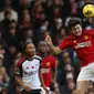 Pemain MU, Harry Maguire (tengah, berhasil mengamankan bola di udara dari jangkaun pemain Fulham dalam pekan ke-11 Premier League 2023/2024 yang berlangsung di Stadion Craven Cottage, London, Sabtu (4/11/2023) malam WIB. (AFP/Adrian Dennis)