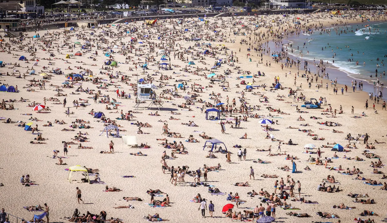 Orang-orang mengunjungi pantai Bondi di Sydney, Australia pada 5 Oktober 2020. Pengunjung ramai berjemur dan bermain di pantai dan berenang di laut saat pandemi Covid-19 masih berlangsung.  (Photo by DAVID GRAY / AFP)