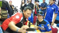 Pembalap Monster Energy Yamaha Factory MXGP Team asal Swiss, Jeremy Seewer berfoto bersama seorang fans-nya sebelum ajang MXGP 2019 seri ke-12 sirkuit Mijen, Semarang. (Bola.com/Vincentius Atmaja)