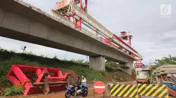 Warga melintas diarea proyek pembangunan double-double track (DDT) Manggarai-Jatinegara, Jakarta, Kamis (30/11). Pengembangan infrastruktur kereta api tersebut merupakan bagian dari rencana transportasi nasional. (Liputan6.com/Angga Yuniar)