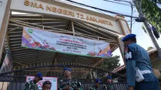 Personel militer berjaga di gerbang sebuah sekolah setelah ledakan di Jakarta, Indonesia, Minggu, 9 November 2025. Hingga Minggu (9/11/2025), SMAN 72 Jakarta di Kelapa Gading, Jakarta Utara, masih dijaga ketat Polisi Militer TNI Angkatan Laut (POMAL). (AP Photo/Achmad Ibrahim)