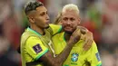 Pemain Brasil, Neymar (kanan) dihibur oleh rekannnya, Raphinha setelah tim mereka kalah dari Kroasia saat laga perempat final Piala Dunia Qatar 2022 yang berlangsung di Education City Stadium, Al-Rayyan, Jumat (09/12/2022) waktu setempat. Brasil kalah 2-4 dari Kroasia saat babak adu penalti. (AFP/Adrian Dennis)