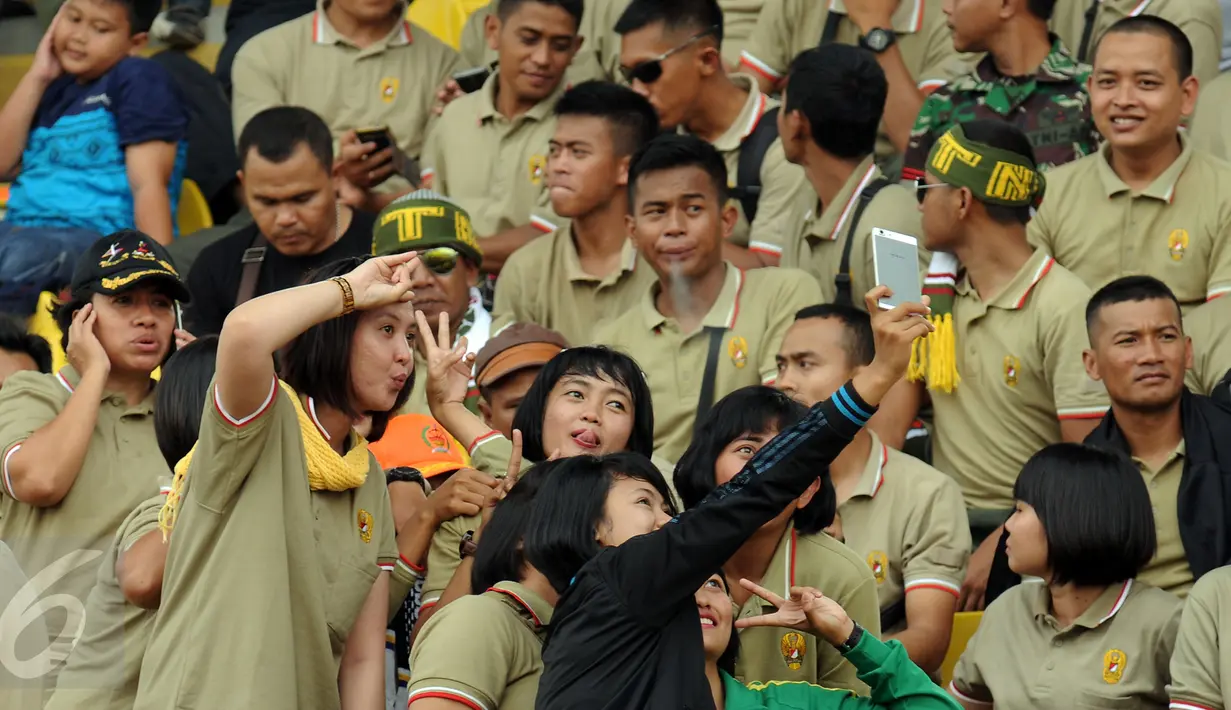 Suporter PS TNI berswadaya foto jelang menyaksikan laga antara PS TNI melawan Sriwijaya FC di Turnamen Piala Bhayangkara, Stadion Si Jalak Harupat, Bandung, Minggu (20/3/2016). PS TNI kalah 1-2 dari Sriwijaya FC. (Liputan6.com/Helmi Fithriansyah)