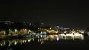 Pandangan umum jembatan Pont d'Austerlitz tercermin di sungai Seine pada malam hari selama penerapan lockdown atau penguncian wilayah di Paris, 23 April 2020. Pandemi corona COVID-19 membuat Prancis menerapkan lockdown. (Ludovic MARIN / AFP)