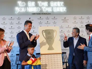 Cristiano Ronaldo saat meresmikan pembukaan Pestana Hotel bersama anaknya Cristiano Ronaldo Jr. dan CEO Pestana Hotel Grup, Dionisio Pestana (2kanan) dan Wali Kota Madeira, Miguel Albuquerque (kanan), di Kepulauan Madeira, (22/7/2016). (AFP/Joana Sousa)