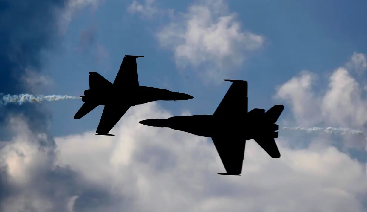 Dua pesawat Blue Angels dari Angkatan Laut AS saling berpapasan dengan kecematan tinggi saat melakukan aksinya di Brunswick, Maine (26/8). (AP Photo / Robert F. Bukaty)