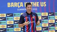 Robert Lewandowski mengenakan jersey saat diperkenalkan sebagai pemain baru Barcelona di Fort Lauderdale, Florida, Rabu (20/7/2022). Senyum lebar terpancar dari wajahnya yang menyapa para penggemar yang hadir dalam acara tersebut. (AP Photo/Marta Lavandier)
