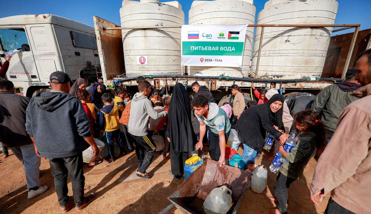 Warga mengisi wadah air dari tangki air portabel di kamp pengungsi Palestina Maghazi, Jalur Gaza tengah pada Rabu 11 Februari 2026. Warga Palestina di Jalur Gaza masih menghadapi kekurangan pasokan air bersih. (Eyad BABA/AFP)