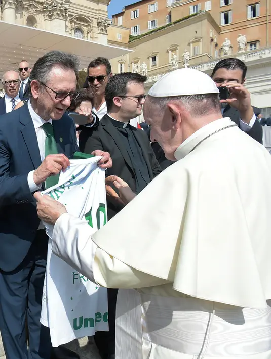 Paus Fransiskus menerima jersey dari presiden tim Chapecoense, Plinio Davide De Nes Filho di Vatikan (30/8). Pertandingan tersebut merupakan pertandingan amal untuk mengumpulkan dana bagi tim Chapecoense. (AP Photo / Andrew Medichini)