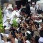 Rizieq Shihab menyapa massa pendukungnya saat tiba di kediamannya di Jalan Petamburan, Jakarta, Selasa (10/11/2020). Rizieq Shihab tiba di kediamannya usai pulang dari Arab Saudi. (merdeka.com/Imam Buhori)