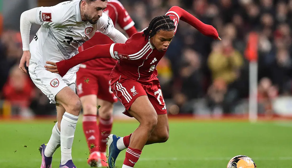Di babak kedua, permainan kedua tim tidak mengendur. Tampak dalam foto, bek Barnsley asal Irlandia, Corey O'Keeffe (kiri) berduel dengan striker Liverpool asal Inggris, Rio Ngumoha saat pertandingan putaran ketiga Piala FA Inggris di Stadion Anfield, pada Senin 12 Januari 2026 waktu setempat atau Selasa (13/1/2026) dini hari WIB. (PETER POWELL/AFP)
