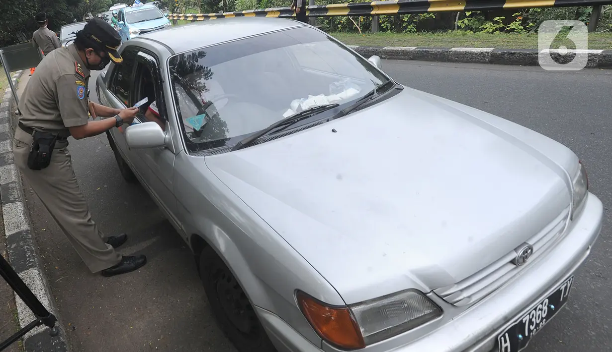 Petugas memeriksa KTP pengendara berplat daerah saat penyekatan kendaraan menuju Jakarta di Kelapa Dua, Jagakarsa, Jakarta Selatan, Rabu (27/05/2020). Masyarakat yang akan memasuki Jakarta wajib mempunyai Surat Izin Keluar Masuk (SIKM), jika tidak akan diminta putar balik. (merdeka.com/Arie Basuki)