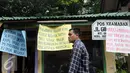 Warga melintas di depan rumah negara yang akan dikosongkan saat mengelar aksi di kawasan sungai bambu, Jakarta Utara, Rabu (3/2). Dalam aksi mereka menolak pengosongan rumah negara secara paksa terhadap 6 rumah negara. (Liputan6.com/Helmi Afandi)