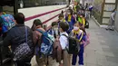 Siswa sekolah dasar mengantre untuk masuk bus sekolah di Hong Kong, Selasa (11/1/2022). Sekolah akan tutup mulai hari Jumat dan sampai setidaknya liburan Tahun Baru Imlek pada minggu pertama bulan Februari. (AP Photo/Kin Cheung)