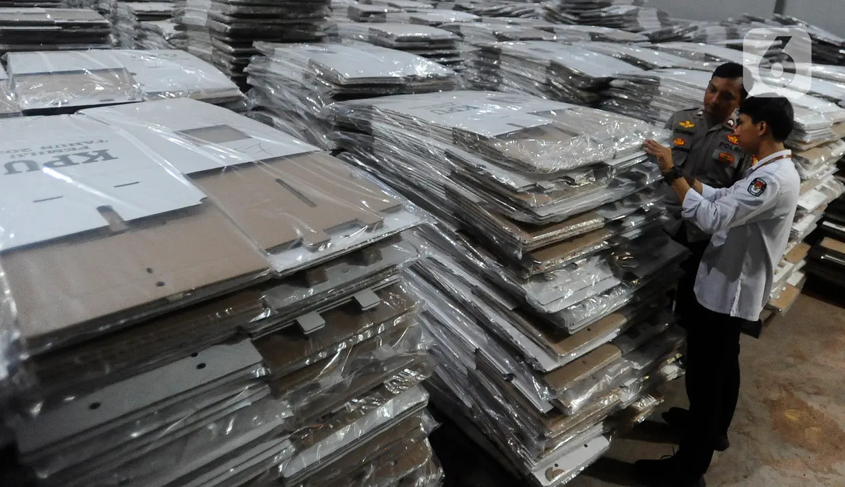 Petugas Komisi Pemilihan Umum (KPU) Kota Tengerang Selatan bersama anggota kepolisian dari Polres Tangerang Selatan mengecek kondisi kotak suara di gudang logistik KPU Kota Tangerang Selatan, Banten, Kamis (7/12/2023). (merdeka.com/Arie Basuki)