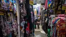 Kawasan ini menjadi tujuan utama warga Surabaya dan sekitarnya untuk berburu takjil dengan harga terjangkau maupun berziarah ke makam Sunan Ampel. Tampak dalam foto, seorang penjual pakaian menggunakan telepon seluler sambil menunggu pelanggan selama bulan suci Ramadan di dekat Masjid Sunan Ampel, Surabaya, Jawa Timur, pada Minggu 8 Maret 2026. (JUNI KRISWANTO/AFP)