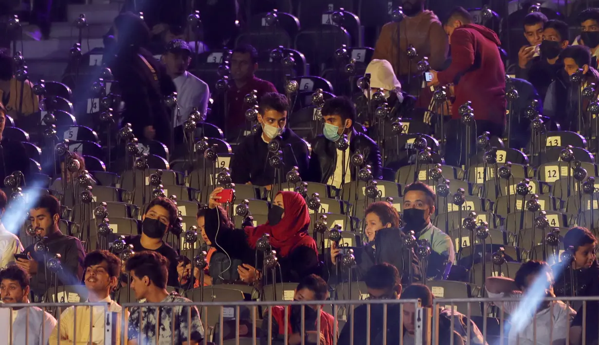 Penggemar gulat mengenakan masker ketika mereka menonton pertandingan gulat WWE Super ShowDown di Riyadh, Arab Saudi, Kamis (27/2/2020). Pertandingan gulat ini diadakan di tengah epidemi virus corona COVID-19  yang telah menyebar hampir ke seluruh penjuru dunia. (AP Photo/Amr Nabil)