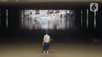Petugas berdiri di antara banjir yang menggenangi underpass Kemayoran, Jakarta, Senin (3/2/2020). Curah hujan tinggi menyebabkan banjir yang menggenangi kawasan tersebut lama surut sehingga menutup arus lalu lintas. (Liputan6.com/Immanuel Antonius)