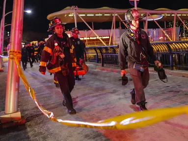 Petugas membawa jenazah korban jatuhnya helikopter di East River di New York City, AS (11/3). Akibat insiden ini, satu korban selamat dan dua korban tewas. (Eduardo Munoz Alvarez/Getty Images North America/AFP)