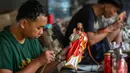 Para pekerja menyemprotkan cat ke patung-patung rohani di bengkel kerajinan Studio Malta Jaya di Bantul, Yogyakarta, pada Kamis 18 Desember 2025. Jelang perayaan Natal 2025, kesibukan terlihat di bengkel kerajinan Studio Malta Jaya di Bantul, Yogyakarta. (DEVI RAHMAN/AFP)