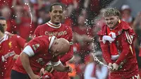 Ekspresi Manajer Liverpool, Arne Slot (kiri), Virgil van Dijk (tengah), dan Harvey Elliott saat merayakan gelar juara Liga Inggris selepas mengalahkan Tottenham Hotspur di Stadion Anfield, Minggu (27/4/2025). (AFP/Paul Ellis)