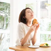 Ilustrasi perempuan yang sedang makan karena lapar/copyright shutterstock.com/miya227