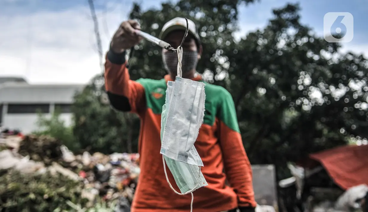 Petugas Sudin LH menunjukkan masker yang ditemukan di Dipo Sampah Kecamatan Pademangan, Ancol, Jakarta, Rabu (24/2/2021). Dengan berbekal alat pemilah, sarung tangan, dan masker, jasa mereka patut dihargai dalam membersihkan lingkungan dari limbah medis. (merdeka.com/Iqbal S. Nugroho)