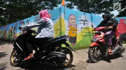 Warga mengendarai sepeda motor melintas di 'Gang Mural', Kelurahan Rorotan, Jakarta, Kamis (29/3). Ide Gang Mural ini diinisiasi oleh Kelurahan Rorotan dan gambar-gambar di sepanjang tembok dilukis oleh petugas PPSU. (Merdeka.com/Iqbal S Nugroho)