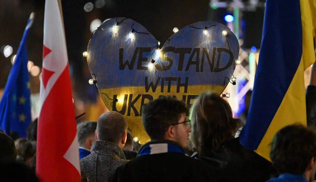 Orang-orang mengambil bagian dalam demonstrasi pro-Ukraina yang menandai tiga tahun invasi Rusia di Berlin pada 24 Februari 2025. (RALF HIRSCHBERGER/AFP)