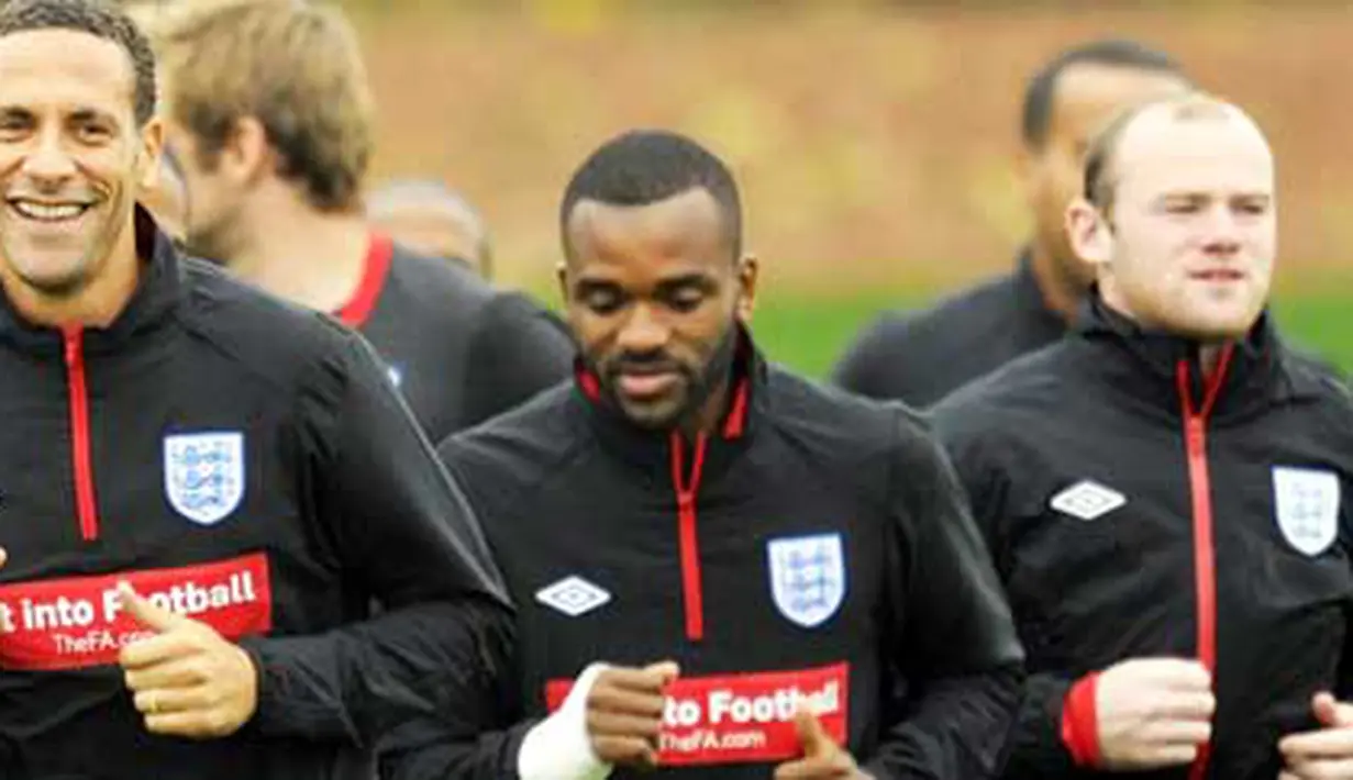 Bek Inggris Rio Ferdinand (kiri) tersenyum saat mengikuti sesi latihan timnas di kamp latihan di London Colney 8 Oktober 2010 jelang laga lawan Montenegro. AFP PHOTO / GLYN KIRK 