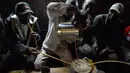 Seorang pria menuangkan racikan minuman beralkohol ke dalam pot di daerah Nairobi, Kenya, Rabu (8/11). Minuman ini adalah bir tradisional Kenya yang terbuat dari dari tepung sorgum, jagung, atau tepung millet. (AFP Photo/Simon Maina)