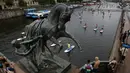 Orang-orang mendayung "paddle board" di sepanjang Sungai Fontanka pada festival SUP (Stand Up Paddle)-Surfing di St.Petersburg, Rusia, Minggu (12/8). Dalam paddling, mereka menggerakkan papannya dengan cara mendayung sambil berdiri. (AP/Dmitri Lovetsky)