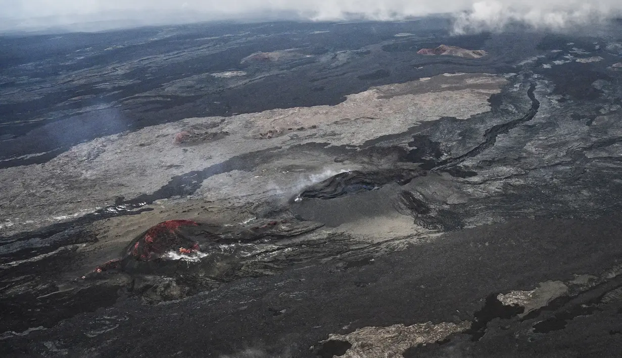 Gunung Api Mauna Loa terlihat dari udara dekat Kailua-Kona, Hawaii, Senin (12/12/2022). Lava merah dari letusan Gunung Berapi Mauna Loa, yang mengalir terang menyebabkan langit Hawaii menjadi merah. (Robyn BECK / AFP)