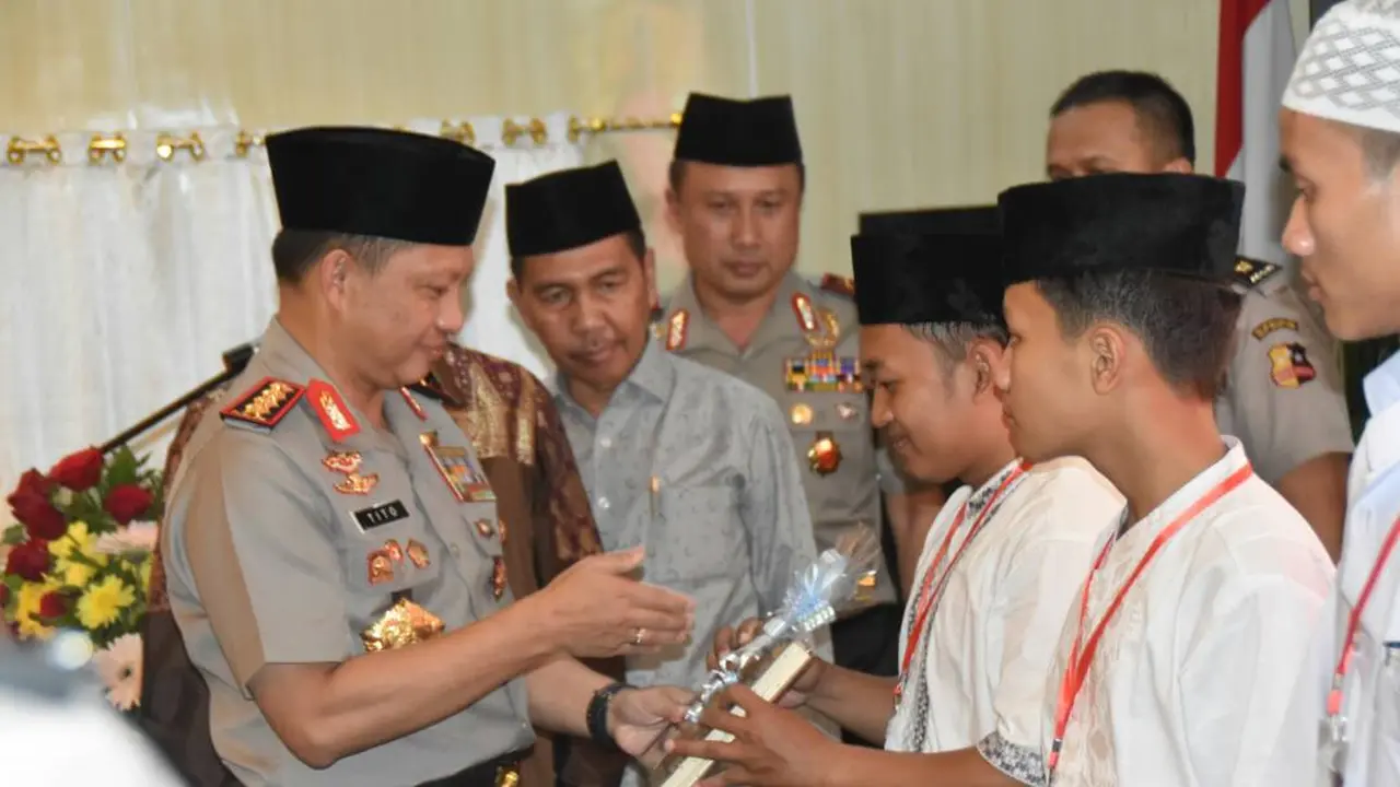 Kapolri Jendral Tito Karnavian memberikan Alquran kepada salah satu santri (Liputan6.com / Nefri Inge)