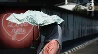 Pejalan kaki mengenakan payung untuk menghindari panas matahari di kawasan Kuningan, Jakarta, Selasa (26/9/2023). (merdeka.com/Imam Buhori)