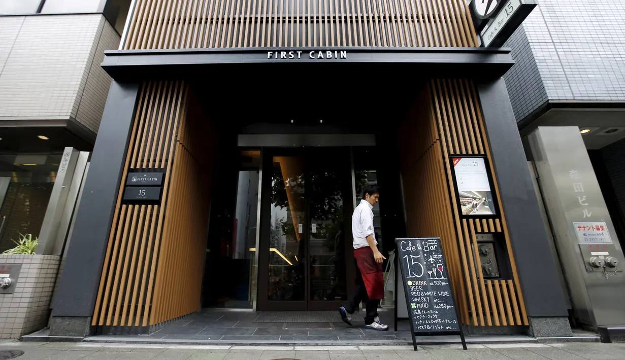 Seorang pria berjalan di depan pintu masuk First Hotel Cabin, Tokyo, Jepang (30/7/2015). Layanan kelas bisnis di Hotel First Cabin menawarkan interior yang unik dan nyaman. (Reuters/Toru Hanai)
