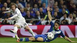 Pemain Real Madrid, Luka Modric, dihadang pemain Wolfsburg, Ricardo Rodriguez pada leg kedua perempat final Liga Champions di Stadion Santiago Bernabeu, Madrid, Rabu (13/4/2016) dini hari WIB. (AFP/Javier Soriano)