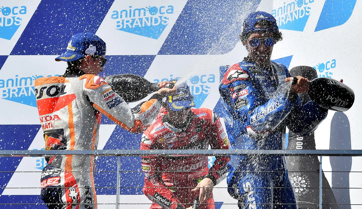 Pembalap Spanyol dari tim Repsol Honda, Marc Marquez (kiri ke kanan) bersama Francesco Bagnaia (Ducati Lenovo) dan Alex Rins (Suzuki Ecstar) merayakan kemenangan Grand Prix MotoGP Australia di Sirkuit Phillip Island, Minggu (16/10/2022). Marc Marquez finish di posisi kedua dan ini menjadi podium pertamanya sejak kembali pasca operasi keempat cedera patah lengan tangan kanan. (Paul CROCK/AFP)