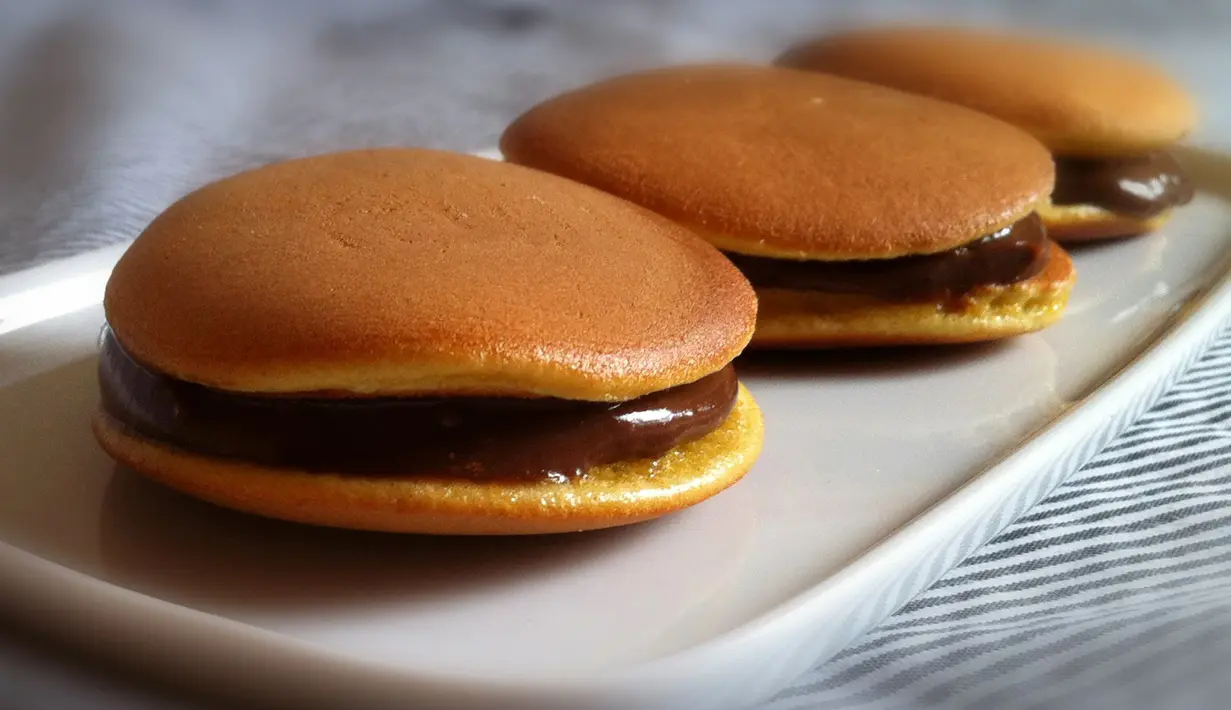 Dorayaki merupakan kue favorit doraemon yang merupakan kue tradisional khas jepang. Kue ini biasanya tengahnya berisi selai kacang merah, cokelat, atau matcha. Tekstur lembut dan rasanya yang manis membuat kue ini banyak digemari. (Istimewa)