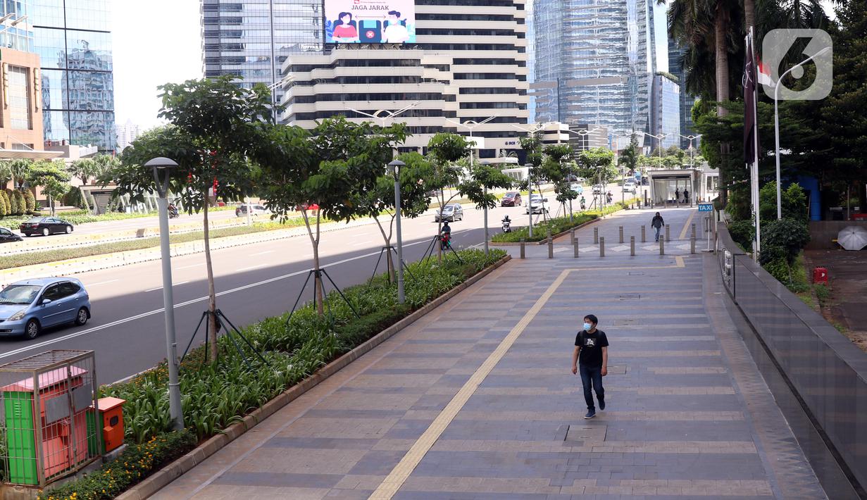 Seorang pria berjalan di pedestrian kawasan Sudirman, Jakarta, Jumat (25/12/2020). Libur Natal dan Tahun Baru 2021 membuat jalanan di beberapa wilayah Ibu Kota terpantau lengang tanpa kemacetan. (Liputan6.com/Angga Yuniar)