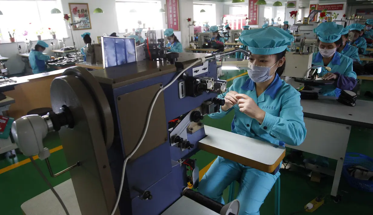 Pekerja memakai masker di Pabrik Sepatu Kulit Wonsan, tempat mereka memproduksi sepatu kulit buatan tangan di Wonsan, Provinsi Kangwon, Korea Utara pada 28 Oktober 2020. (AP Photo/Jon Chol Jin)