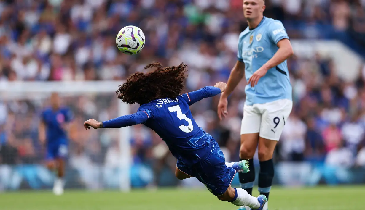 Pemain Chelsea, Marc Cucurella (kiri) berusaha menghalau pemain Manchester City, Erling Haaland pada laga Liga Inggris 2024/2025 di Stamford Bridge, London, Inggris, Minggu (18/08/2024) WIB. (AFP/Adrian Dennis)