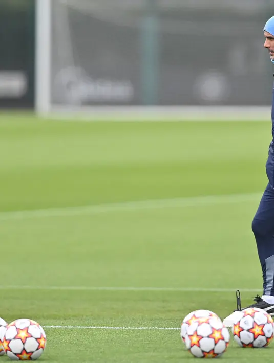 Pelatih Manchester City, Pep Guardiola memimpin sesi latihan di tempat latihan Manchester City di Manchester, barat laut Inggris (4/4/2022). Man City akan bertanding melawan Atletico Madrid pada leg pertama perempat final Liga Champions di Etihad Stadium. (AFP/Paul Ellis)