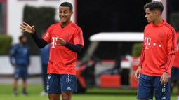 Pemain Bayern Munchen, Philippe Coutinho, berdiskusi dengan Thiago Alcantara saat latihan perdananya di Munchen, Selasa (20/8). Bintang Brasil ini didatangkan dari Barcelona. (AFP/Christof Stache)