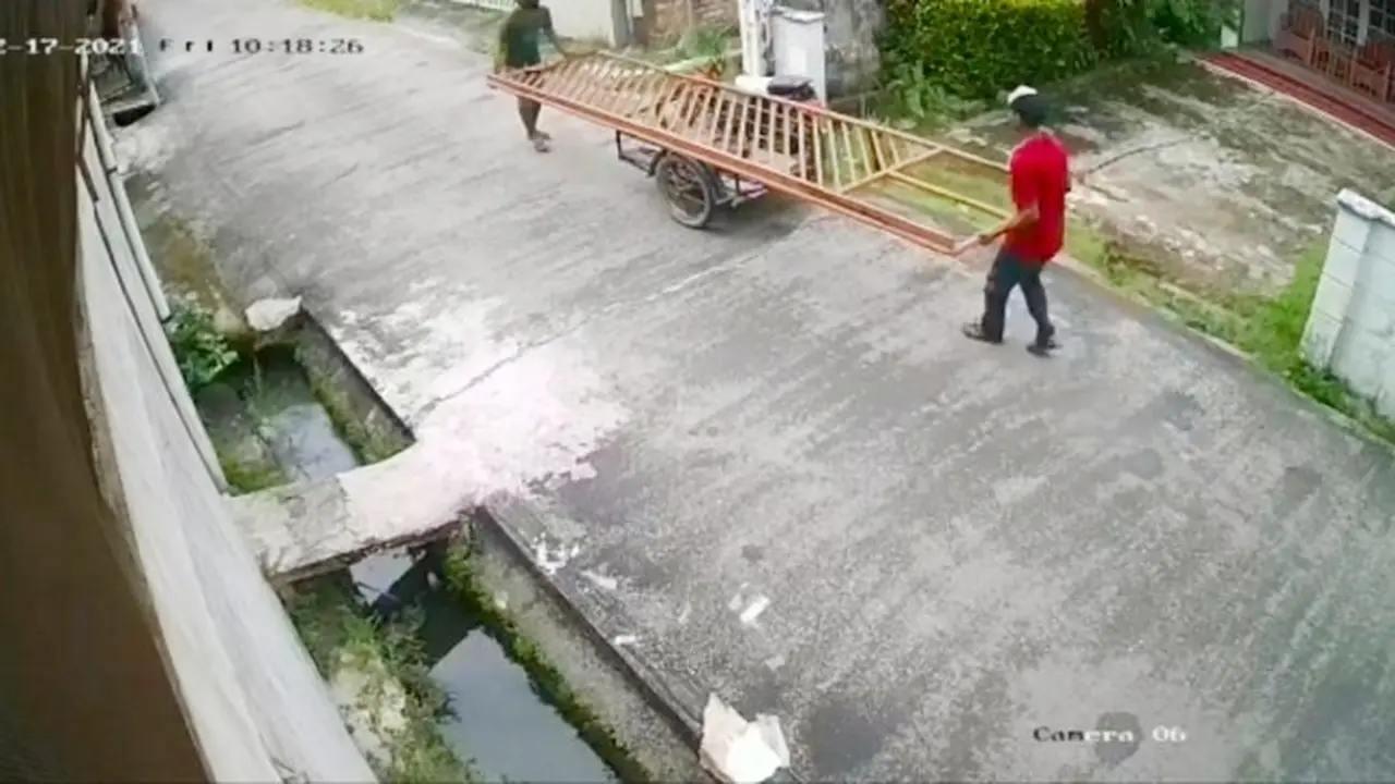 Rekaman CCTV yang memperlihatkan dua pria melakukan pencurian pagar rumah disiang bolong di Pekanbaru.
