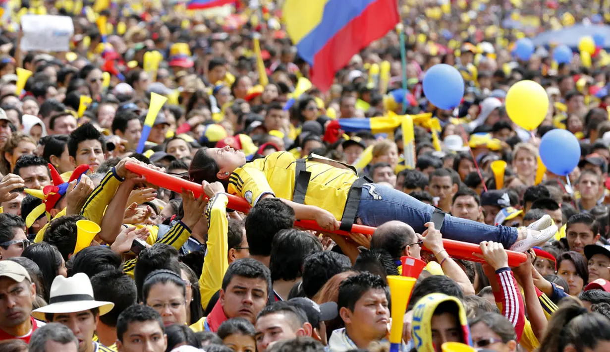 Salah satu suporter wanita Timnas Kolombia pingsan saat berada di tengah-tengah ribuan suporter yang berkerumun di taman Bolivar, Bogota, (6/7/2014). (REUTERS/John Vizcaino)