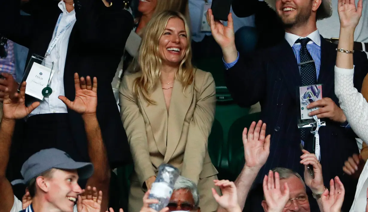 Aktris Inggris-Amerika Sienna Miller tersenyum ketika menghadiri pertandingan tunggal putra antara Ithy's Matteo Berrettini dan petenis Swiss Roger Federer pada hari ketujuh dari Kejuaraan Tenis Wimbledon di London (8/7/2019). (AP Photo/Alastair Grant)